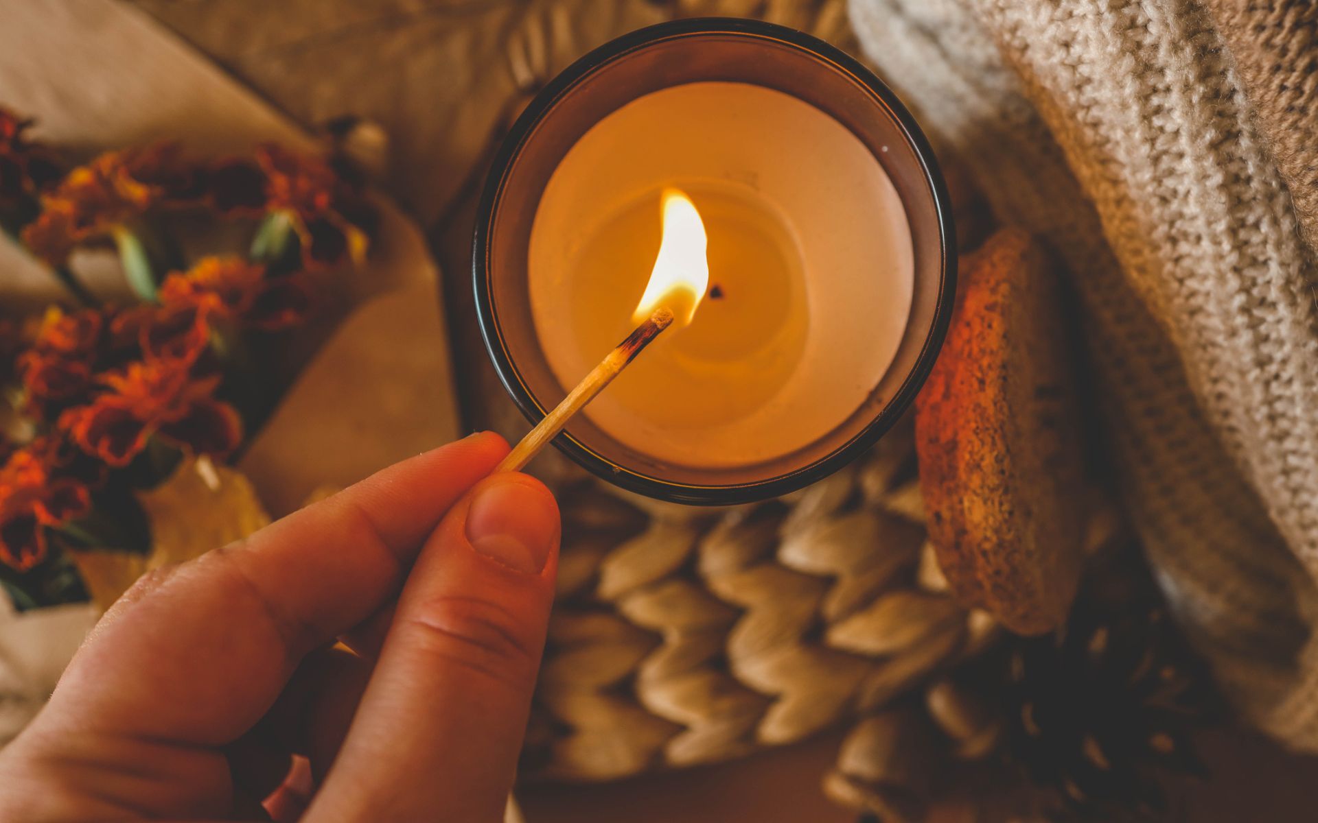 How to Make Your Home Smell Like Fall. Someone lights a candle that smells like fall.