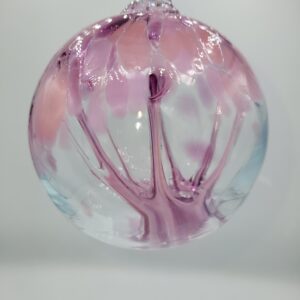 Pink glass ornament with floral design.