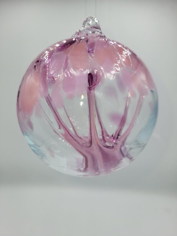 Pink glass ornament with floral design.