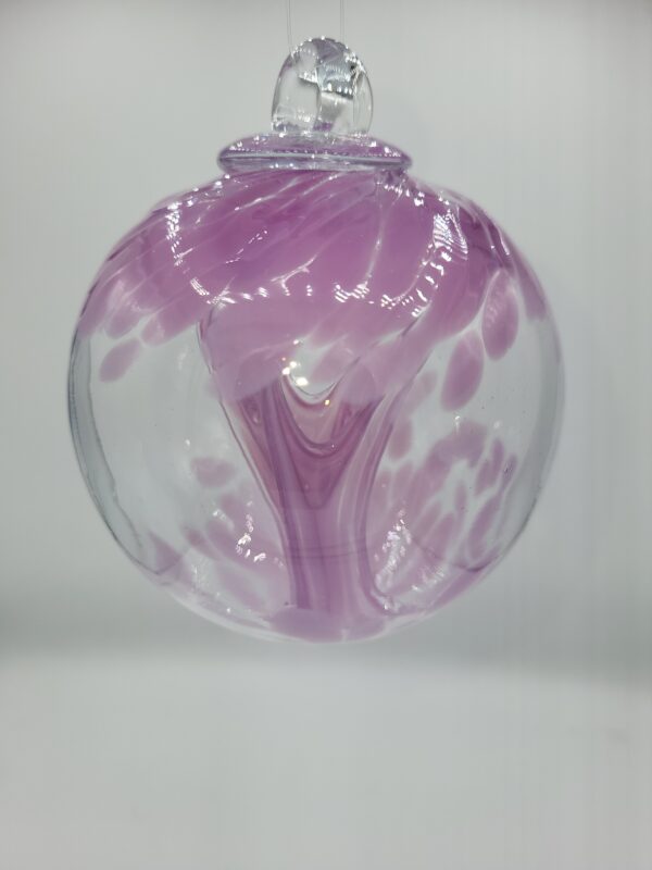 Purple swirled glass ornament hanging on display.