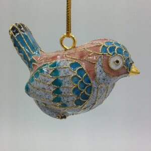 A decorative bird ornament with blue, pink, and gold detailing hangs from a gold string against a plain light background.