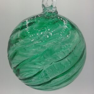 Green glass ornament with swirling pattern.
