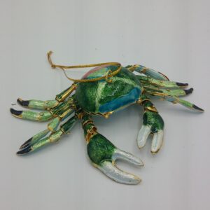 A decorative green and blue crab ornament with gold accents and a hanging loop, displayed against a plain white background.