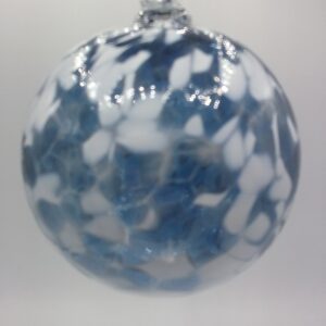 A round glass ornament with a marbled pattern of blue, white, and clear patches, hanging against a plain light background.