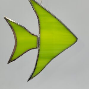 A green stained glass ornament shaped like a fish with silver-colored edges, hanging against a plain light gray background.