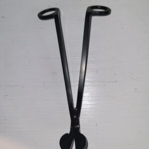 A pair of black metal candle wick trimmers with round finger holes, placed on a white surface.