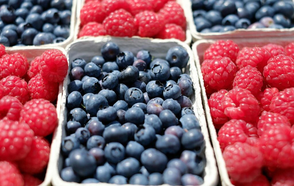 Baskets of fresh raspberries and blueberries
