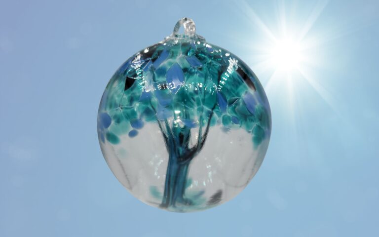 Colorful glass orb with tree design, witch ball