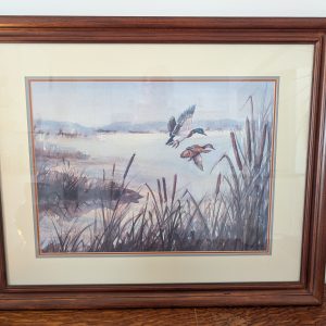 Framed watercolor of flying ducks.